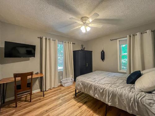 a bedroom with a bed and a ceiling fan at Lakefront Dock Fire Pit Hot Tub Value in Swanton
