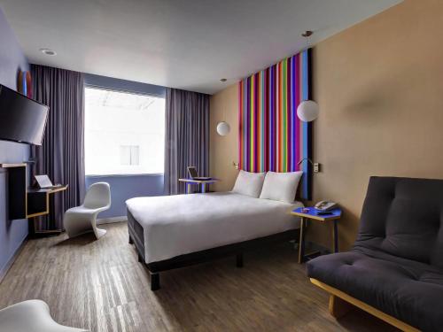 a hotel room with a bed and a couch at Ibis Styles Mexico Reforma in Mexico City