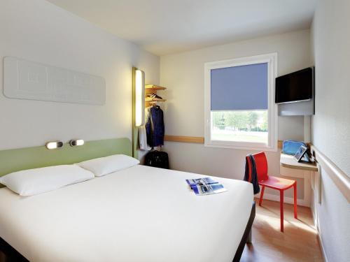 a bedroom with a white bed and a window at ibis budget Saint Pourcain in Saint-Pourçain-sur-Sioule
