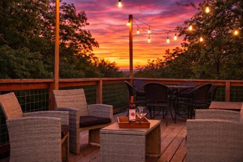 a deck with chairs and tables with a sunset in the background at 25 OFF 1 Mile to IU Walk to Town in Bloomington