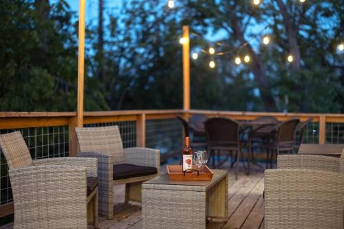 a deck with chairs and a table with a bottle of wine at 25 OFF 1 Mile to IU Walk to Town in Bloomington