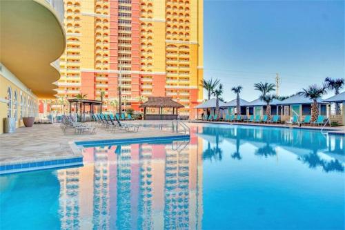 a large swimming pool in front of a large building at Amazing Sunsets Steps to Pier Park Heated Pool Hot Tub in Panama City Beach