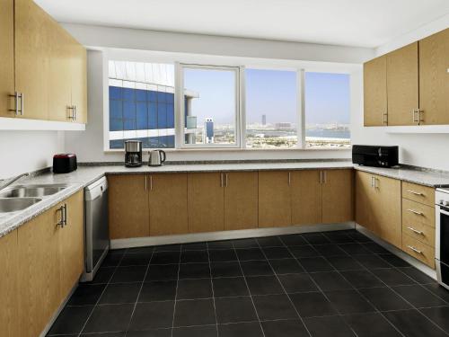 an empty kitchen with a view of the city at Adagio Premium Dubai Al Barsha in Dubai