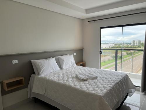 a bedroom with a bed with a large window at Hotel Blox Sorriso in Sorriso