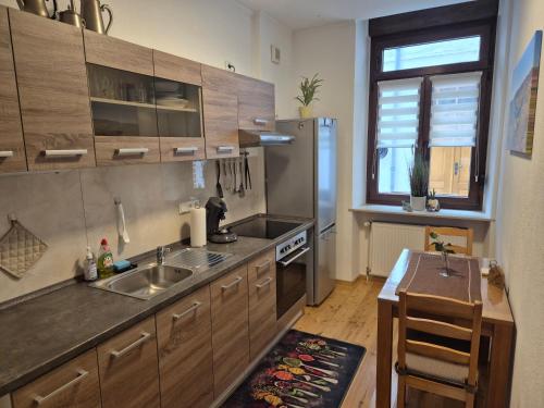 a kitchen with a sink and a refrigerator and a table at Ehemaliges Winzerhaus Cochem in Cochem