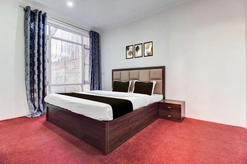 a bedroom with a large bed and a window at Hotel O Wave Inn in Srinagar
