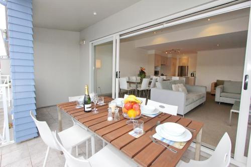 a dining table and chairs in a living room at Crow's Nest Apartments in Whitianga