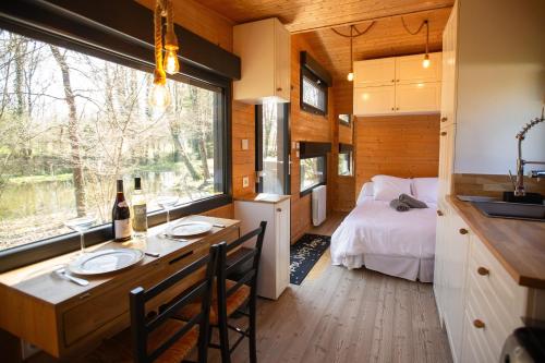 a room with a bed and a kitchen with a table at Les Chalets Horizon in Saint-Just-de-Claix