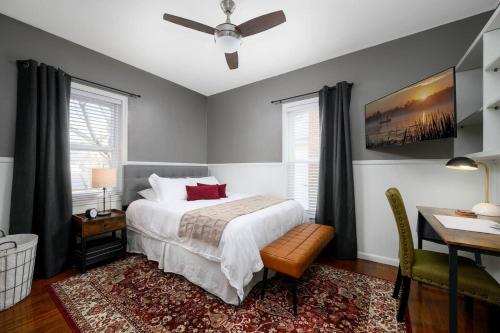 a bedroom with a bed and a desk and window at Elegant House 2 min from BSU/Hospital/Downtown in Muncie