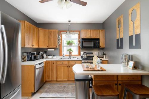 a kitchen with wooden cabinets and a stainless steel refrigerator at Elegant House 2 min from BSU/Hospital/Downtown in Muncie