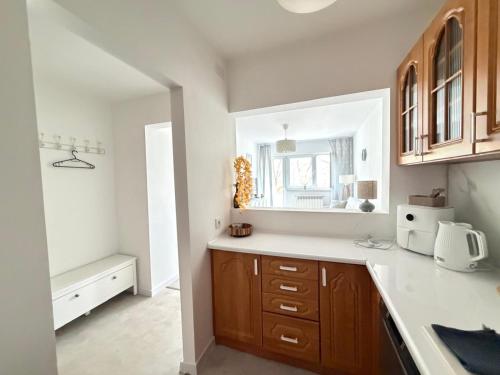 a kitchen with wooden cabinets and a sink and a window at Silesia Park Bytom 24H Park Miejski Centrum in Bytom