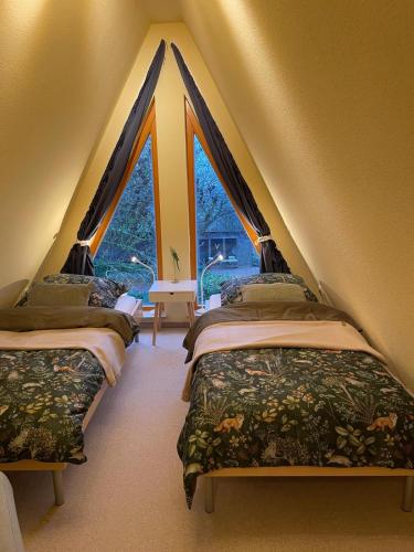 three beds in a room with a large window at Giebelblick Barweiler in Barweiler