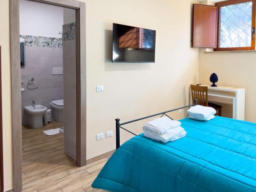 a bedroom with a blue bed and a bathroom at Casale Saporito in Montopoli in Sabina