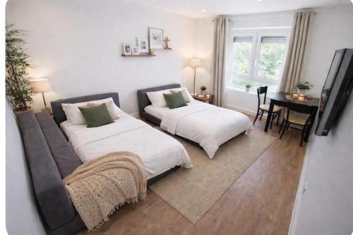 a bedroom with two beds and a table with a desk at Apartment Heide in Soltau