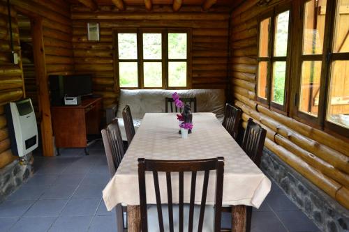 a dining room with a table and chairs in a cabin at La Araucaria in Potrerillos