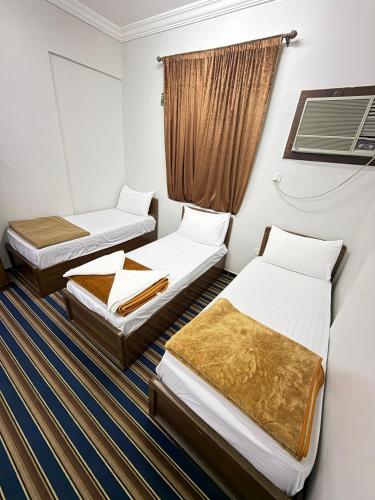 a room with two beds and a window at فندق صفوة الجميزة in An Naqāʼ