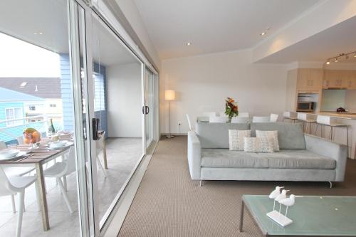 a living room with a couch and a table at Crow's Nest Apartments in Whitianga