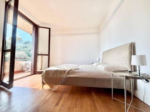 a bedroom with a bed and a table and a window at D'Annunzio in Gardone Riviera