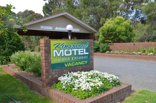 a sign for a motel with flowers around it at Kingswood Motel in Tocumwal