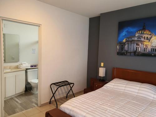 a bedroom with a bed and a bathroom with a building on the wall at Lujoso Penthouse en la Roma in Mexico City