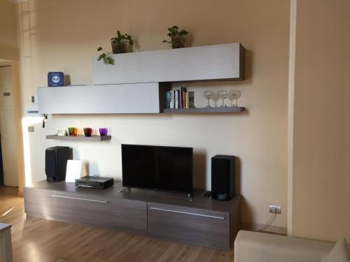 uma sala de estar com uma televisão de ecrã plano e colunas em Morsenchio Flat em Milão