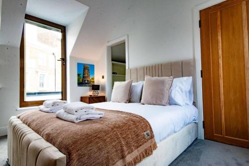 a bedroom with a large bed with towels on it at Luxury Seaside Home, Sleeps 6 in Broadstairs