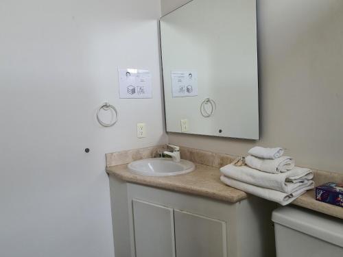 a bathroom with a sink and a mirror and towels at Lujoso Penthouse en la Roma in Mexico City
