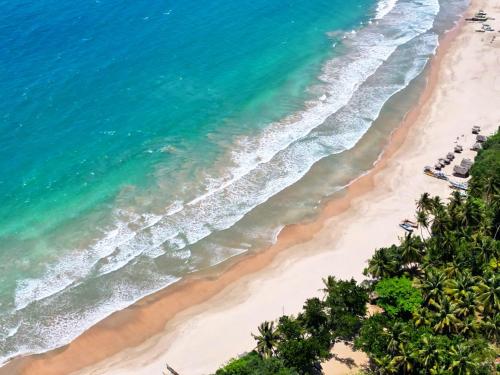an aerial view of a beach with palm trees and the ocean at Podi Beach House Mawella in Tangalle