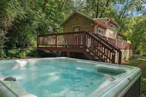 a hot tub with a deck and a house at Ryon Tiny Home Cabin City-side Rustic Retreat in Chattanooga