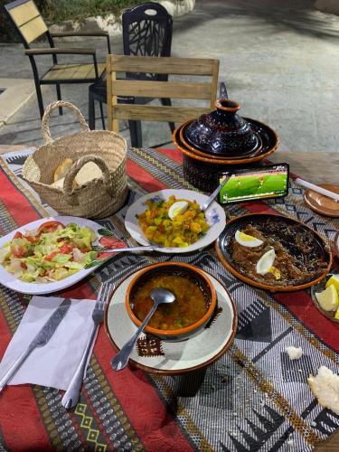 a table topped with plates of food on a table at Dar Sana in Qaşr al Ḩallūf