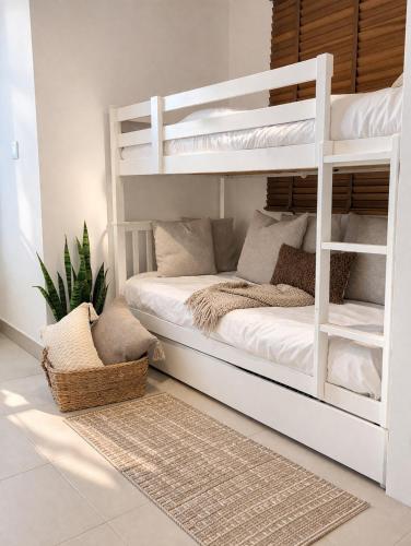 a white bunk bed in a white room at Manzar View - Private Rooftop Dining & Epic Views in As Sīfah
