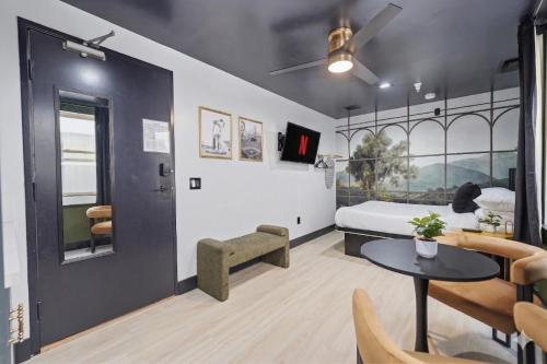 a bedroom with a bed and a table and chairs at The Neon Elm Hotel in San Diego