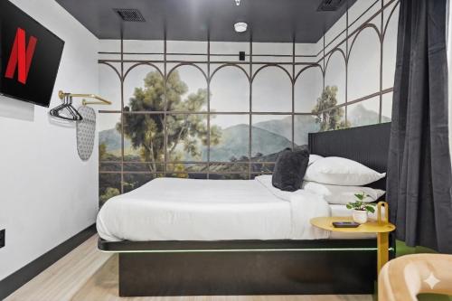 a bedroom with a large bed with a large window at The Neon Elm Hotel in San Diego
