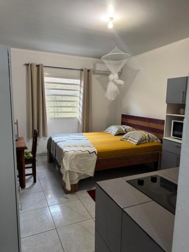 a bedroom with a bed with a yellow bedspread at Discrétion 17 B in Saint-Laurent du Maroni