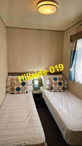 two beds sitting next to each other in a room at Lyons Sunnysands - Hillside 019 in Barmouth