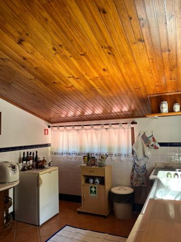 a kitchen with a wooden ceiling and a sink at Quinta de Carcavelos Agroturismo e Enoturismo in Celorico de Basto
