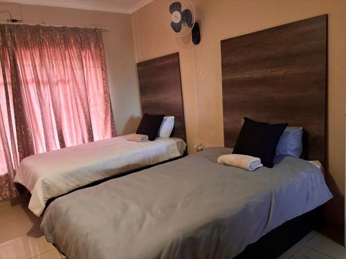 two beds sitting next to each other in a bedroom at Amatis House in Mokopane