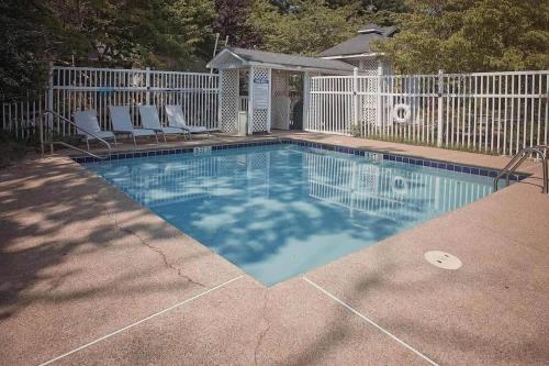 a swimming pool with chairs and a white fence at LMI -15- Laurel Falls Room: Summers Night in Lookout Mountain