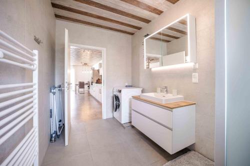 a bathroom with a sink and a washing machine at Haus Sonnengelb in Taarstedt