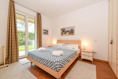 a bedroom with a bed and a window at MGH- Lake Serenity Apartment in Padenghe sul Garda