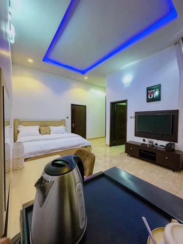 a bedroom with a bed and a tv and a table at Bold 3 Bedroom Apartments in Abuja