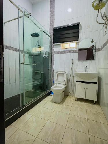 a bathroom with a shower and a toilet and a sink at Bold 3 Bedroom Apartments in Abuja