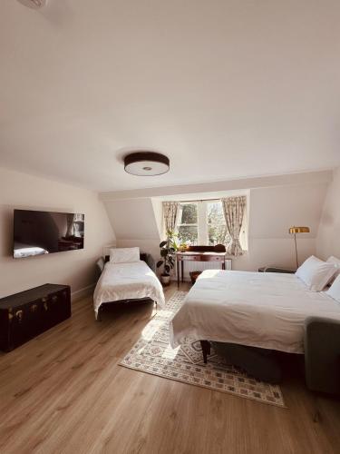 a bedroom with two beds and a television in it at Courtyard Apartament in Ballymore