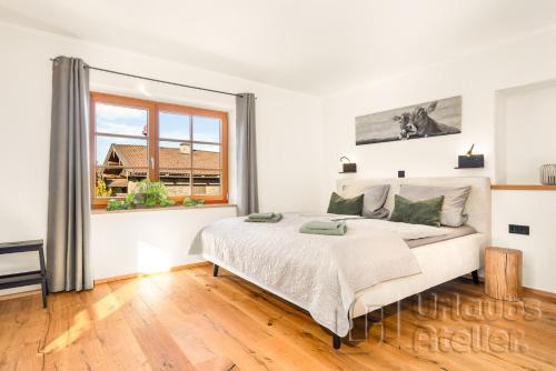 a white bedroom with a bed and a window at Ferienwohnung Antretter **** in Neubeuern