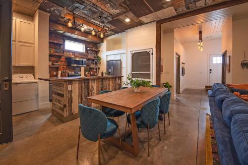 a kitchen and dining room with a wooden table and blue chairs at The Frothy Flat- A Bunny Slippers Optional Destination in Chattanooga