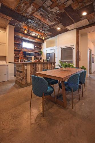a kitchen with a wooden table and blue chairs at The Frothy Flat- A Bunny Slippers Optional Destination in Chattanooga