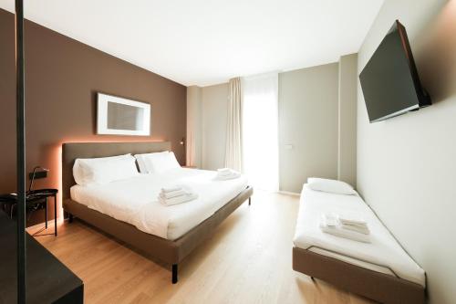 a bedroom with a bed and a flat screen tv at Camoma Aparthotel - Boutique Hotel & Suites in Jesolo