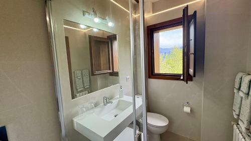 a bathroom with a sink and a toilet and a window at Posada El Bosque in Mieses