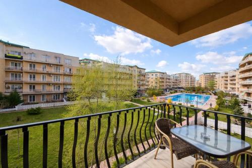 a balcony with a table and chairs and a pool at Salvatore Apartment #BucharestAirport in Ştefăneştii de Sus