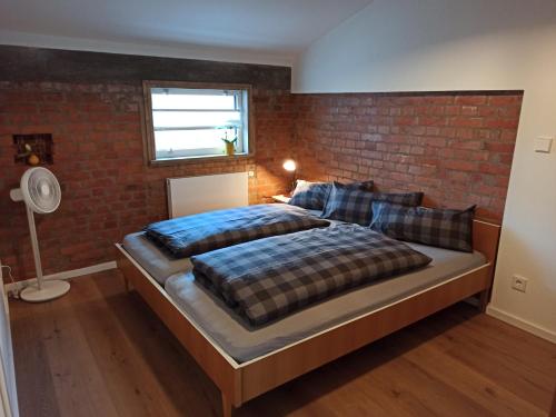 ein Schlafzimmer mit einem Bett vor einer Ziegelwand in der Unterkunft Auszeitbude Mudau, FeWo auf 48 m2 in Mudau